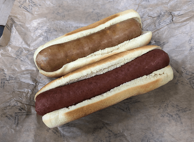 a sam's club hot dog next to a sam's club cheddar dog in buns