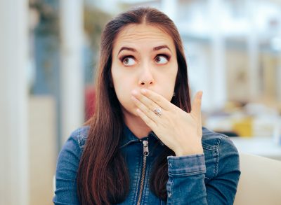 Woman Sitting in a Restaurant Feeling Sick and Nauseated. Young person eating out feeling full and unwell from overeating