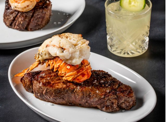 stk steak with lobster tail next to a cocktail and steak