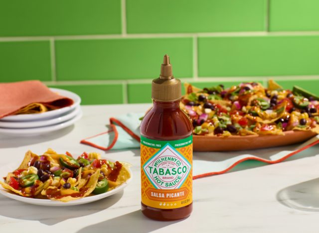 tabasco salsa picante in front of plates of nachos