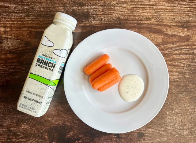 trader joe's buttermilk ranch dressing on a plate with baby carrots next to the bottle of dressing