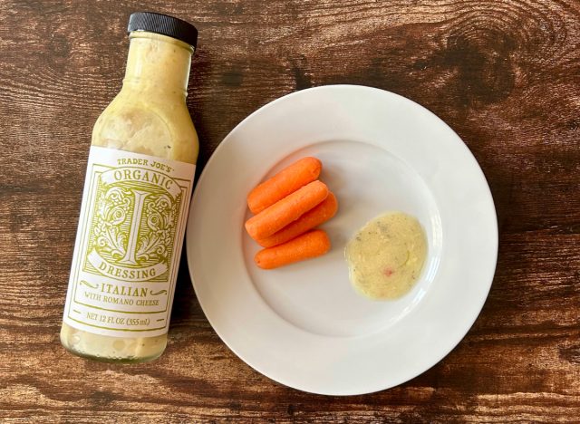 trader joe's organic italian dressing on a plate with baby carrots next to the bottle of dressing