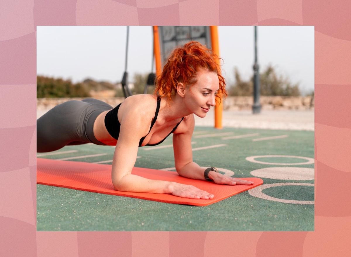 fit woman doing forearm plank exercise on yoga mat on field