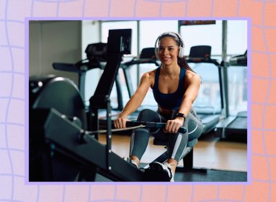 happy, fit woman performing a rowing machine workout in bright gym