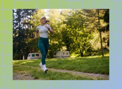 fit, happy woman running on woodsy trail on sunny afternoon