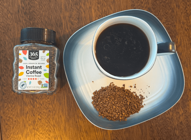 a can of 365 instant coffee with a mug of it on a plate 