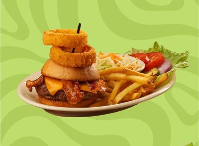 Black Angus Steakhouse Classic Burger with Onion Rings on a plate with fries