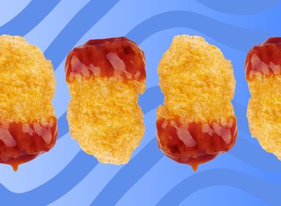 Chicken nuggets dipped in ketchup on a blue background