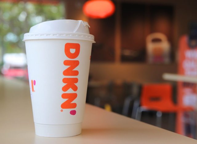 Dunkin' coffee cup sitting on counter in store