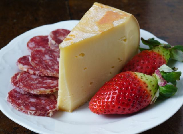 wedge of fontina cheese with sausage and strawberries