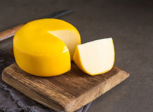 gouda cheese wedge on a wooden slab