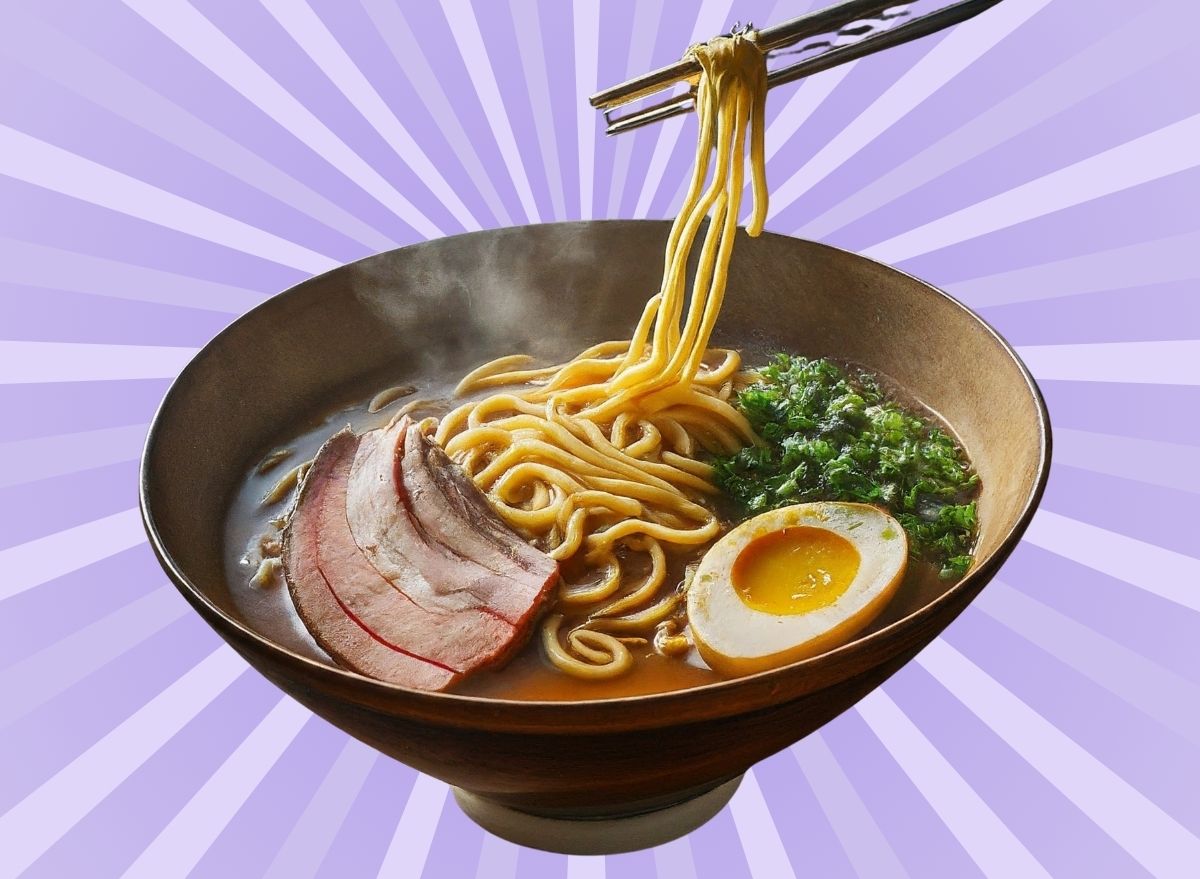 A bowl of piping hot ramen soup set against a vibrant violet background