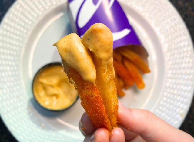 Taco Bell Nacho Fries dipped in cheese sauce