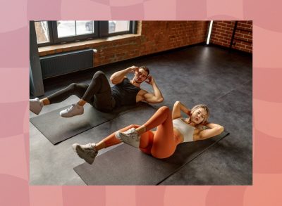 fit couple doing bicycle crunches in gym