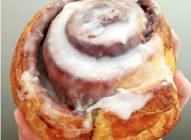 au bon pain cinnamon roll being held by a hand