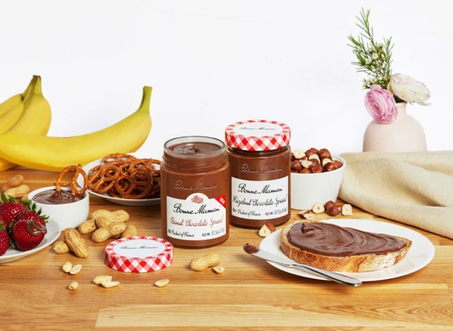 bonne maman peanut chocolate spread on table with pretzels, peanuts, strawberries, and bananas