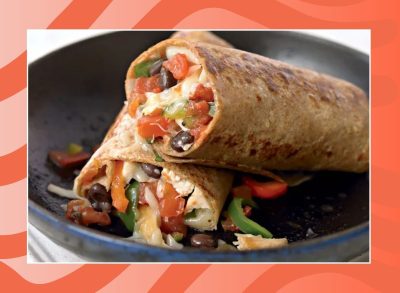 chicken burrito on a plate with a red background