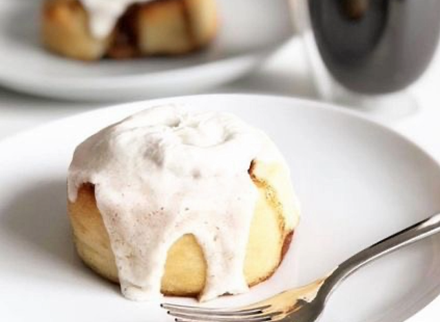 a cinnaholic cinnamon roll on a white plate