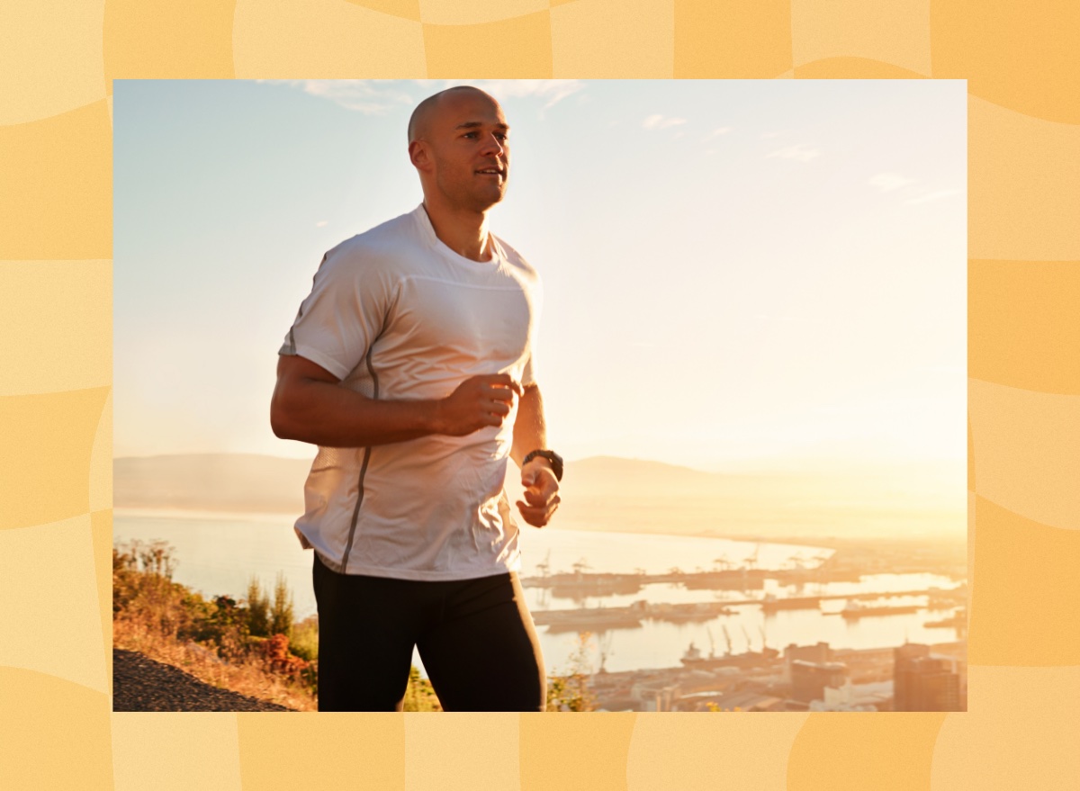 fit man jogging or running on a hilltop road at sunset