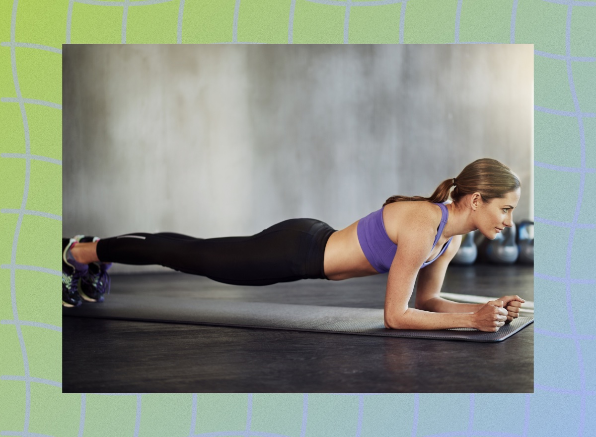 fit woman doing forearm plank in fitness studio