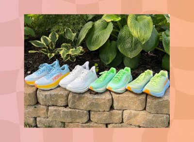 four pairs of colorful HOKA sneakers lined up on stone wall in garden