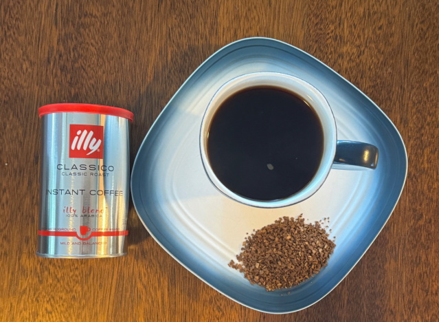 a can of illy instant coffee next to a mug of black coffee 