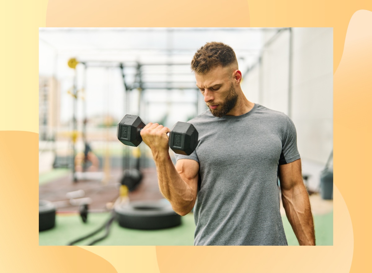 fit, muscular man lifting a dumbbell at outdoor gym