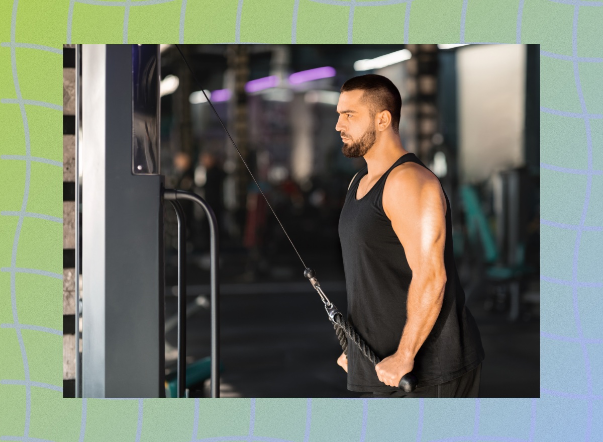 focused, muscular man using a cable machine at the gym