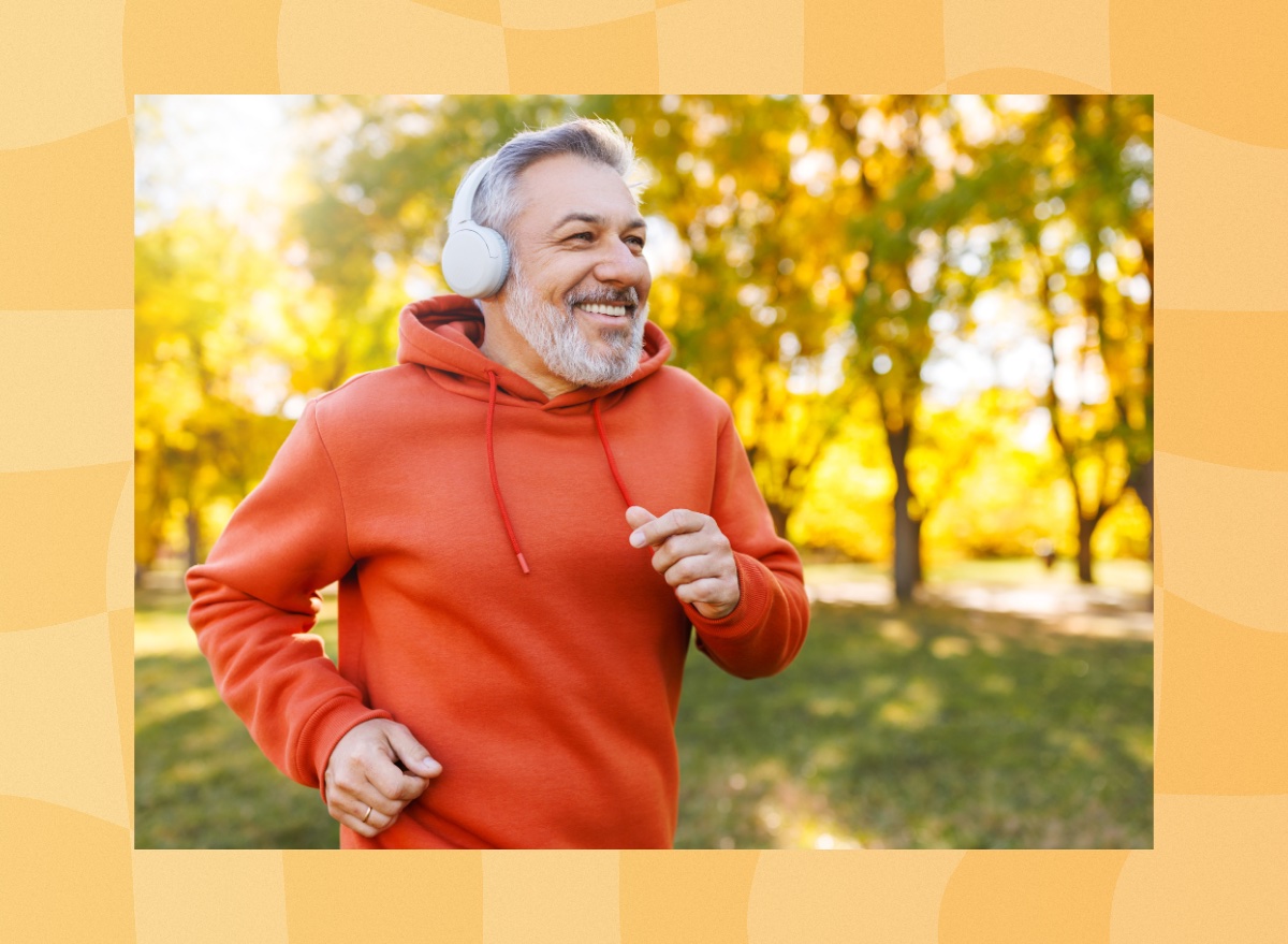 fit, mature man running outdoors on fall afternoon through the park