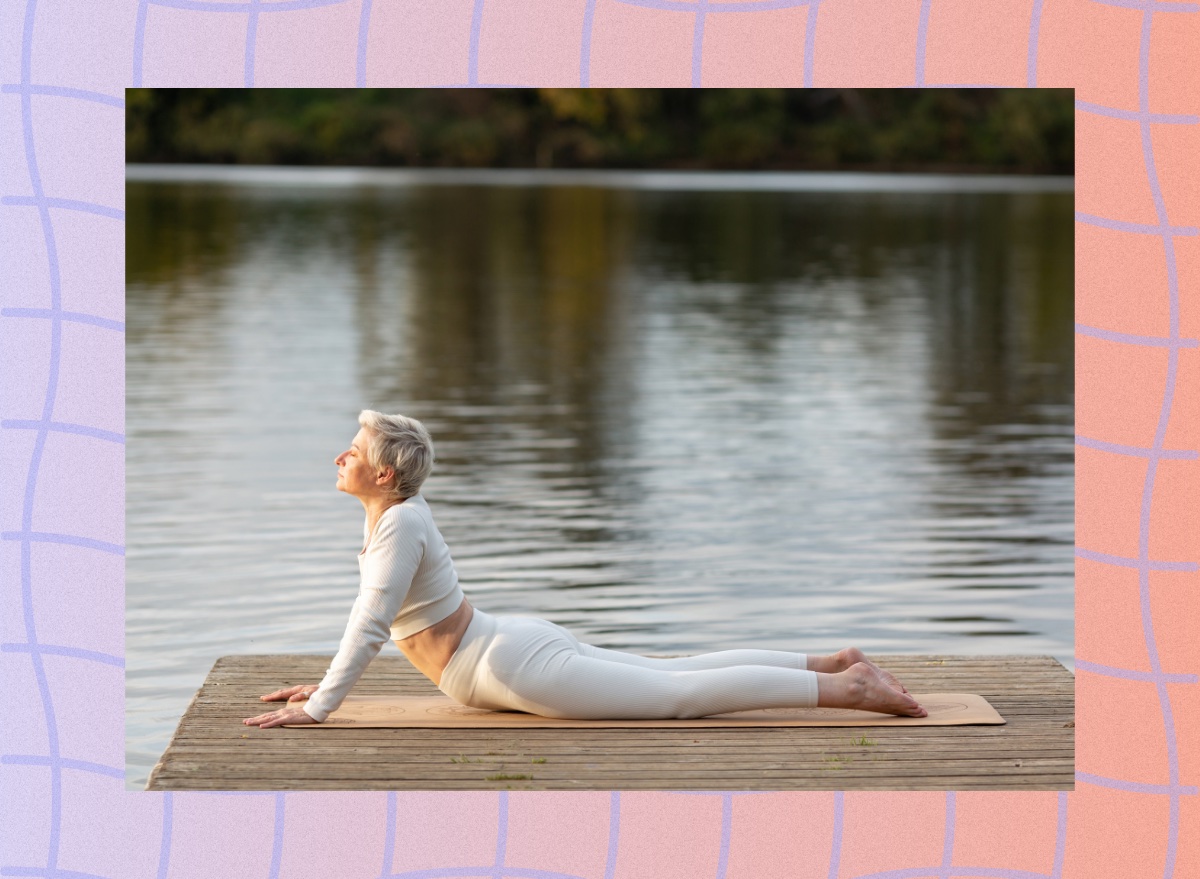 mature woman doing cobra pose on dock by a lake