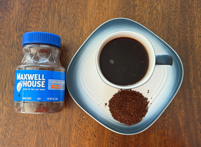 a can of maxwell house coffee next to a mug