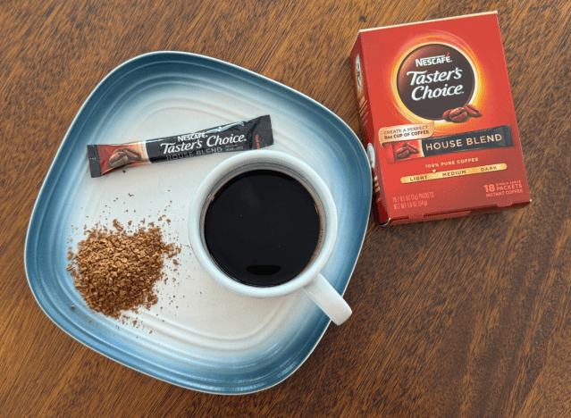 nescafe tasters choice instant coffee box next to mug of black coffee