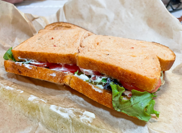 a panera blt cut in half on a wrapper 