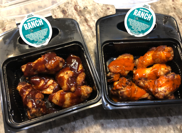 two orders of papa john's wings open on a table 