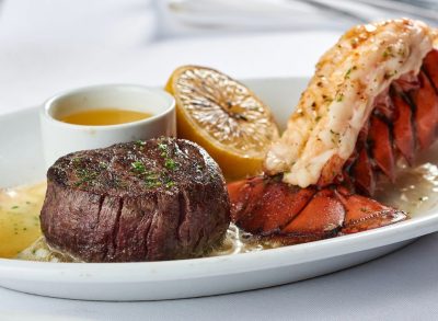 ruth's chris steak and lobster on a plate with half a lemon