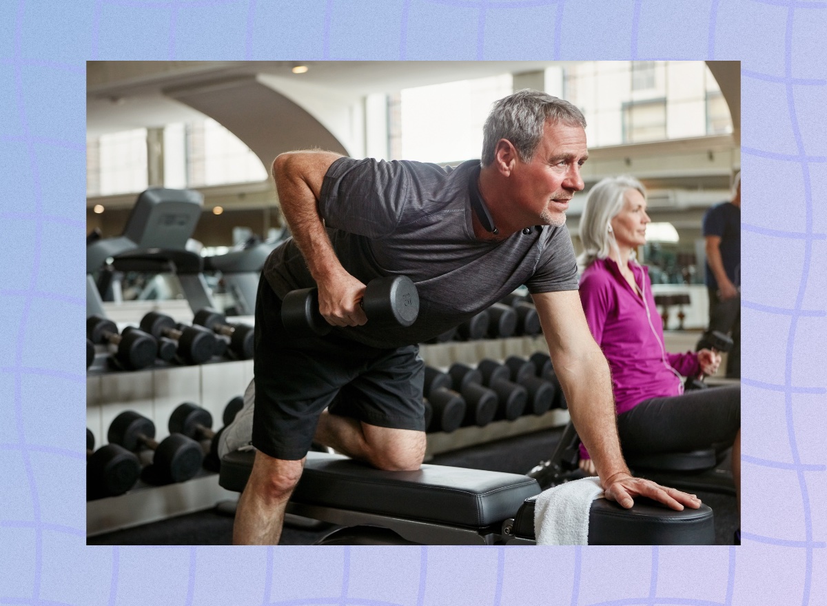 mature man doing single-arm bent-over row at the gym in the weight room