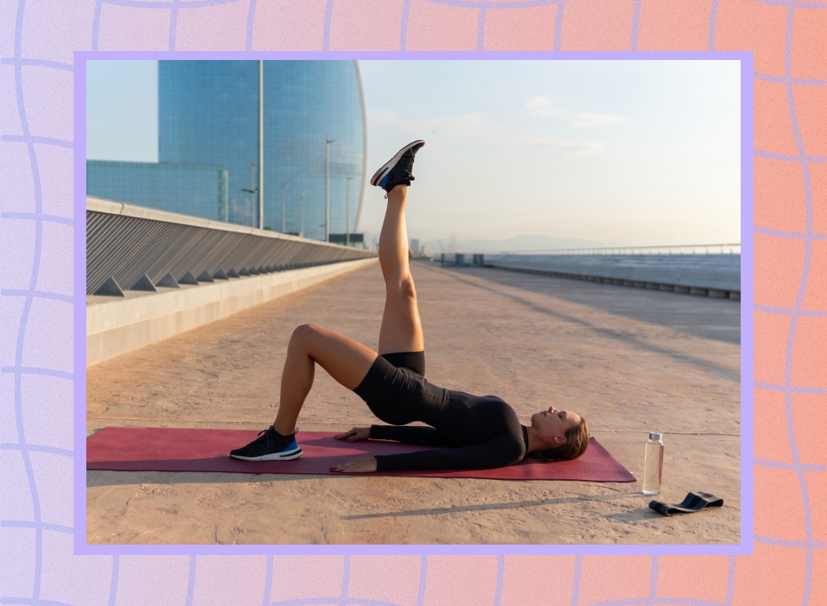 woman doing single-leg glute bridge on yoga mat outdoors