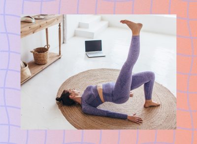 fit brunette woman in purple athletic set doing a single-leg glute bridge exercise in bright living space