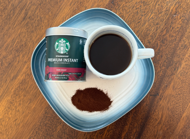 starbucks instant coffee can next to mug of black coffee