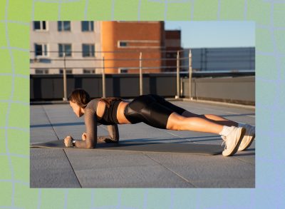 fit woman doing forearm plank exercise on yoga mat on rooftop