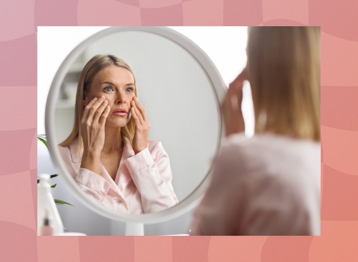 middle-aged woman looking at face in mirror