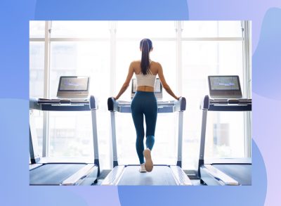 fit woman doing treadmill walk at the gym in line of treadmills by bright windows