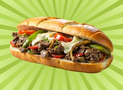 A Philadelphia-style cheesesteak with peppers set against a vibrant background.