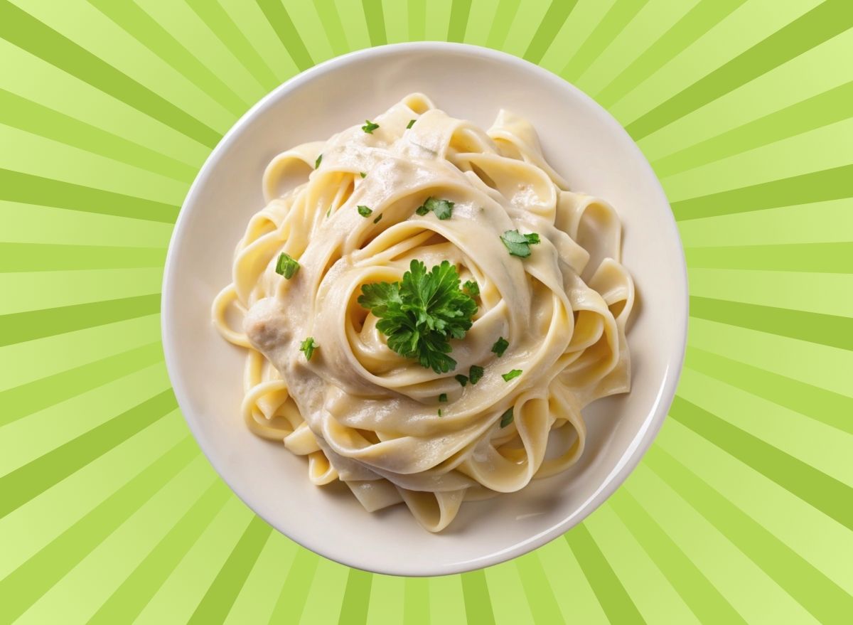 A bowl of fettuccine Alfredo set against a colorful background.