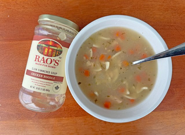 A jar of Rao's Chicken Noodle beside a bowl of the soup