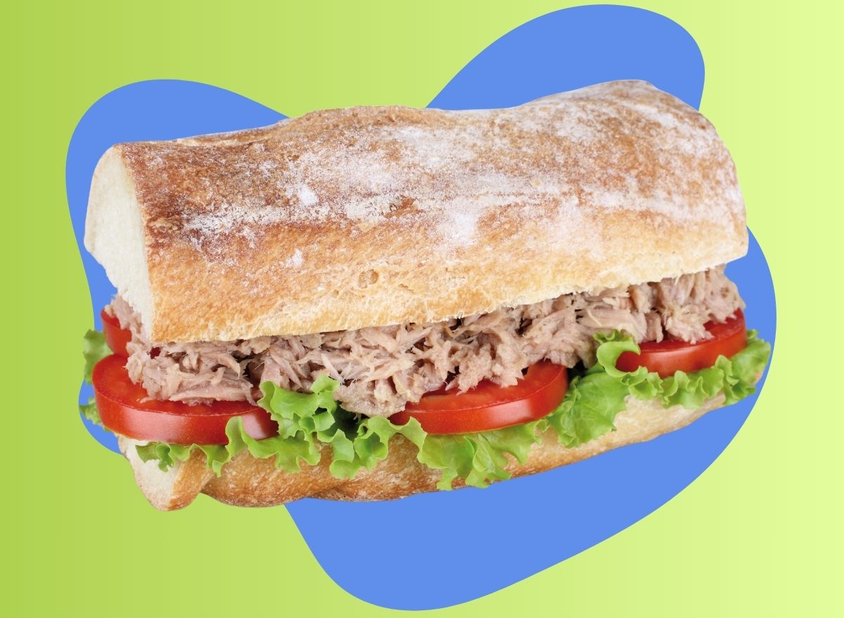 A tuna salad sandwich set against a colorful background.