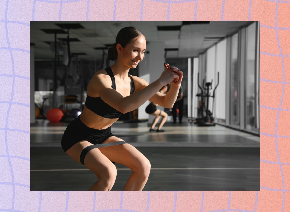 woman doing a resistance band squat at the gym