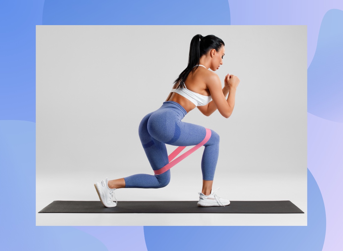 fit sportswoman doing a banded reverse lunge on black yoga mat in front of light gray backdrop