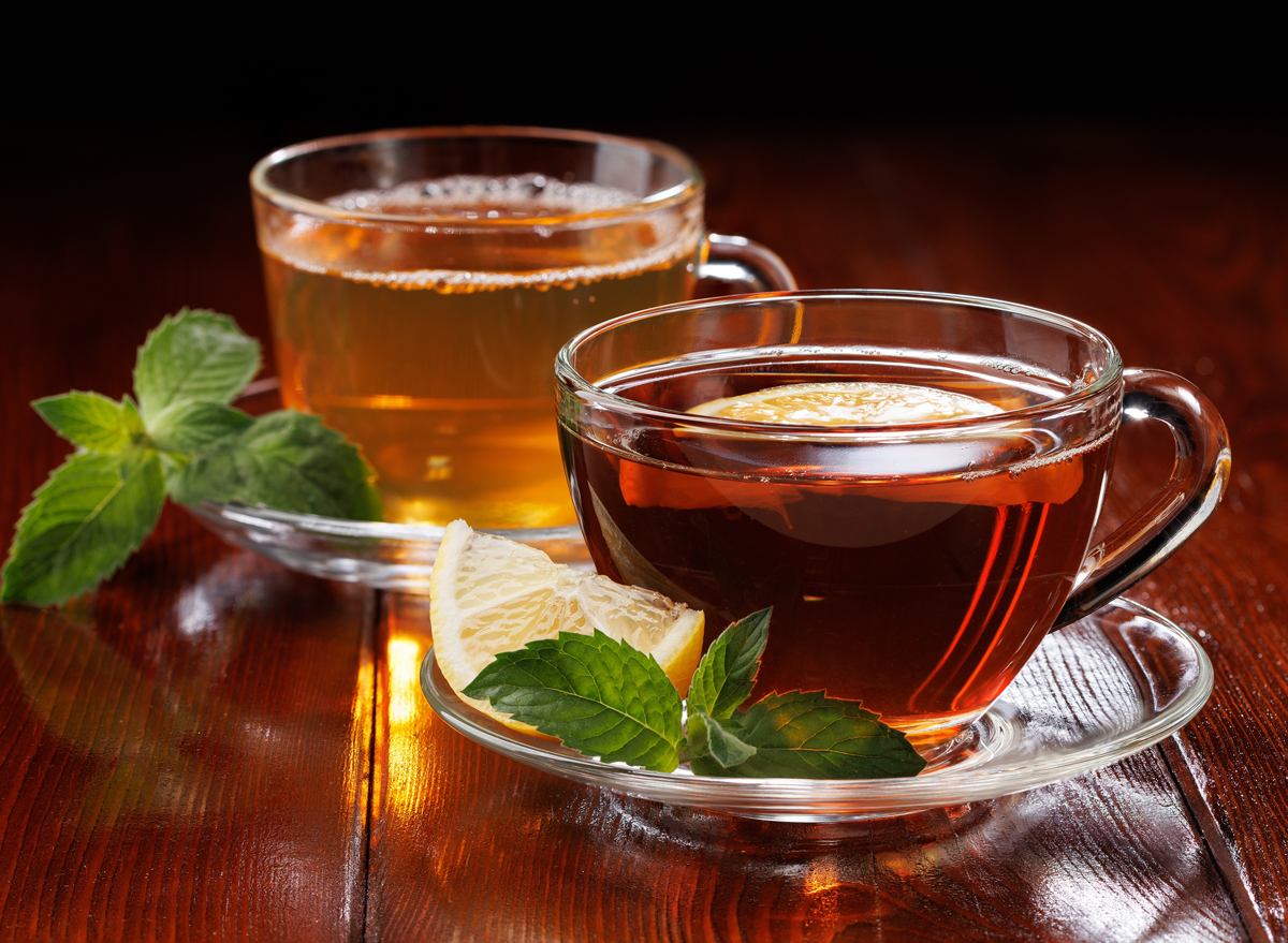 Hot green tea with mint and black tea with lemon and mint in glass cups. Side view. Selective focus.