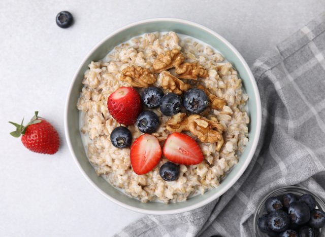 bowl of steel cut oats turned into oatmeal topped with blueberries and strawberries